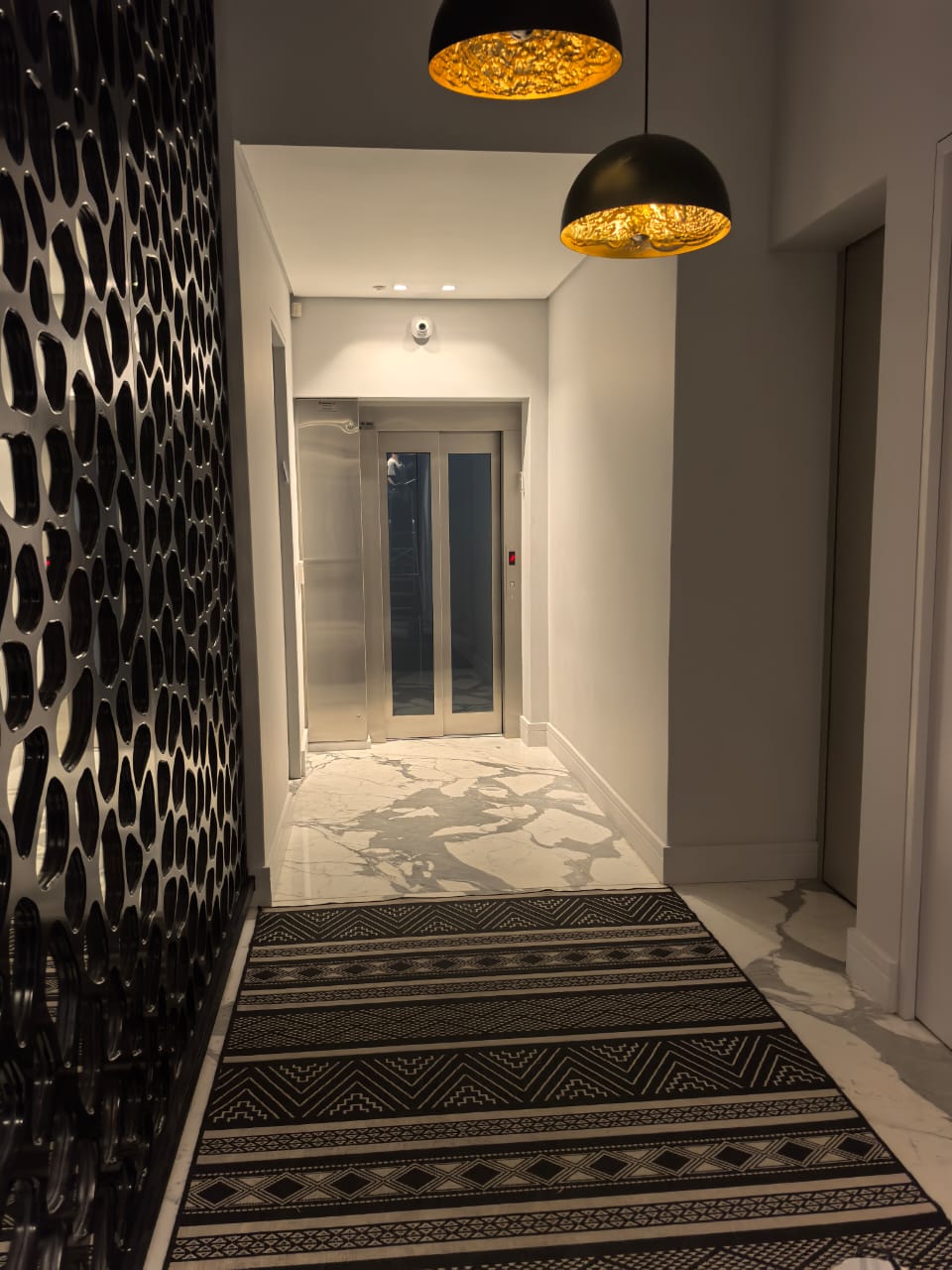 Entrance hallway with marble floors, feature screen and pendant lighting