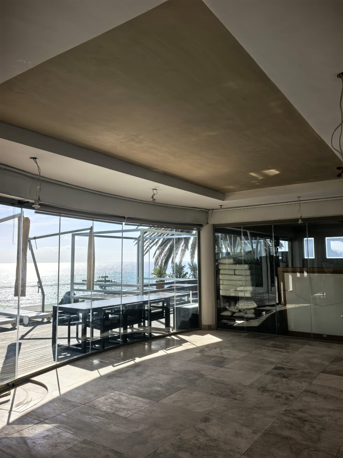 Open living area with frameless stacking glass doors and a sea view
