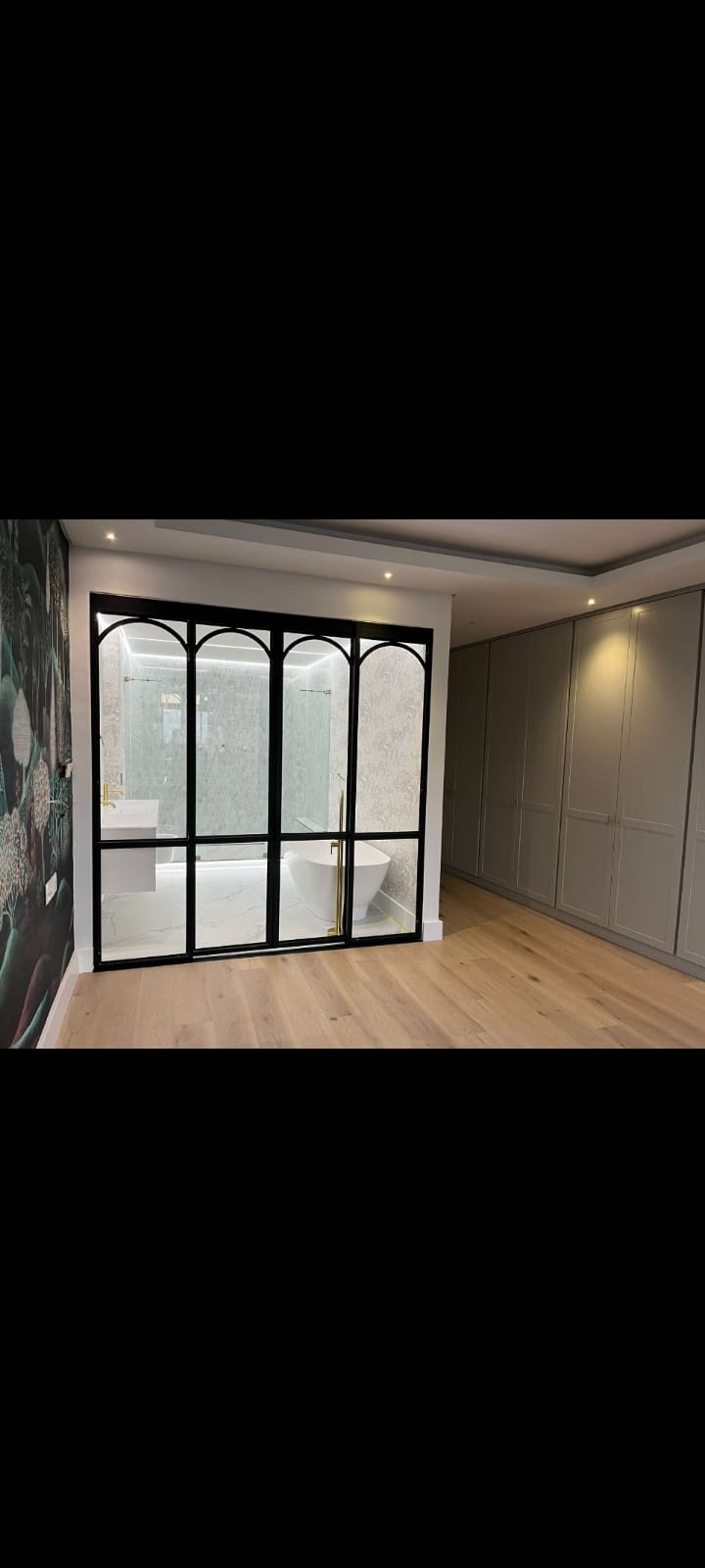 Crittall-style glass partition with built-in wardrobes